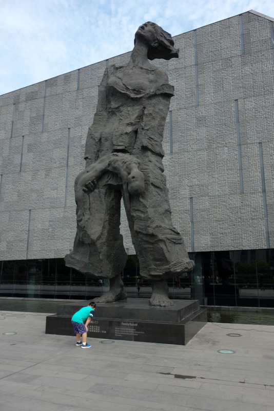 China-Nanjing-Massacre-Museum - Giant statue of woman holding dead baby. The statues are stylised on photos you can see inside, which includes an infant breastfeeding off its dead mo