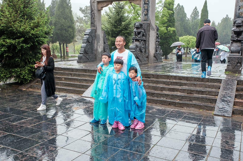 China-Dengfeng-Shaolin-Kung Fu-Rain - A plastic coated family. Note the bootie things on their feet, you can buy them too. Everyone slipping over had bought those booties. I have no idea h