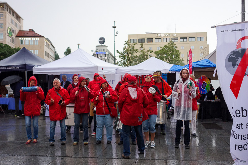 Germany-Munich-Rain-Oktoberfest - After peak rain, this group of protesters came out to play a song on their drums about aids.