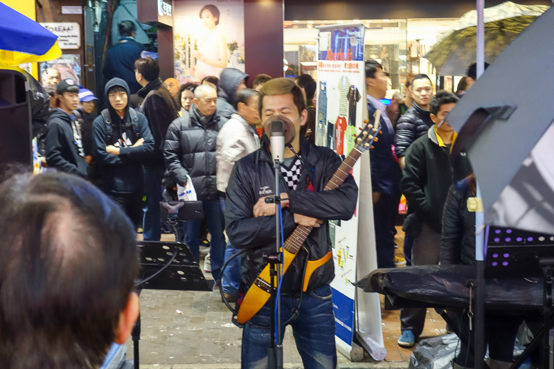 Hong Kong-Mall-Mong Kok - The buskers take it very seriously despite being terrible. This guy has a decent mic with pop filter, some sort of guitar that cost more than $10 and 