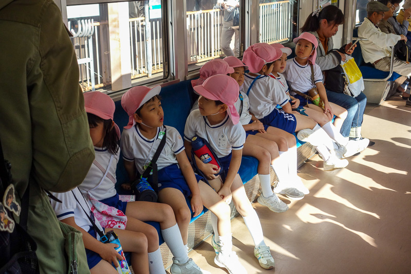 Visiting 9 cities in Japan - Oct and Nov 2016 - I took a photo of school kids. This is the pink hat gang. There was also a yellow hat gang. Along with their hats they all have a drink bottle slung o