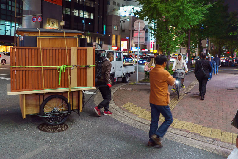 Japan-Fukuoka-Tenjin-Food - This guy is struggling to wheel his food cart across the road. At the same time, all the locals are waving hello to him, and hes putting it down to wa