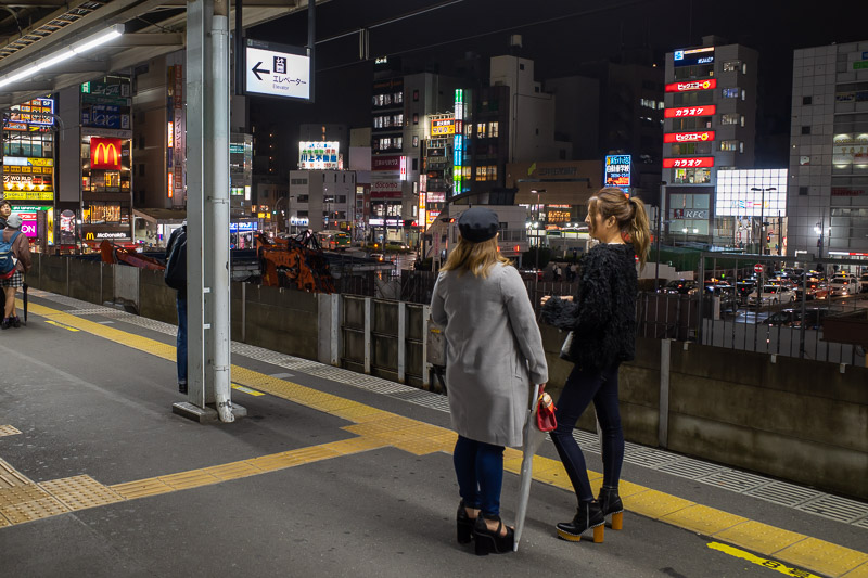 Japan for the 9th time - Oct and Nov 2019 - I like it when train platforms have a view. Not of the girls, of the shops behind it. Although thats some impressive shoes they are wearing to look sl