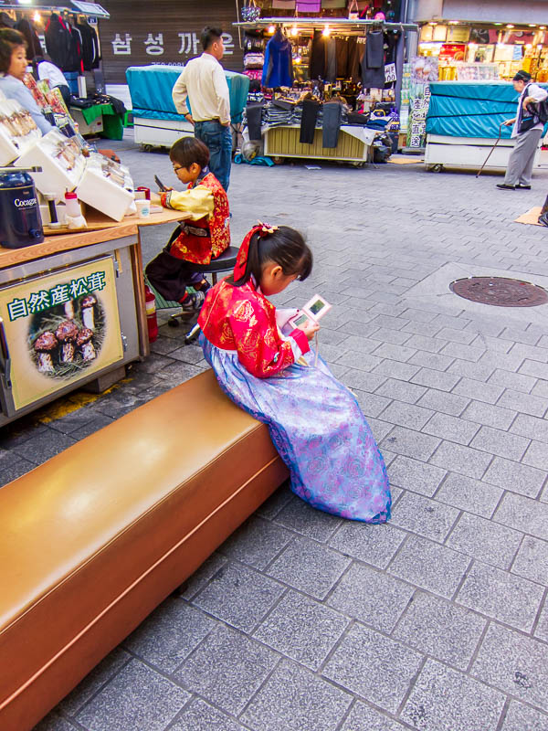 Korea-Seoul-Rubbish - It is slightly amusing seeing a little girl in traditional costume playing a nintendo ds.