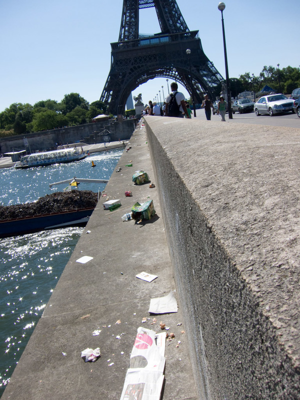 France-Paris-Arc de Triomphe-Eiffel Tower - Check out all the garbage on the bridge with the garbage barge going under? Whos responsible for keeping the streets clean here!!