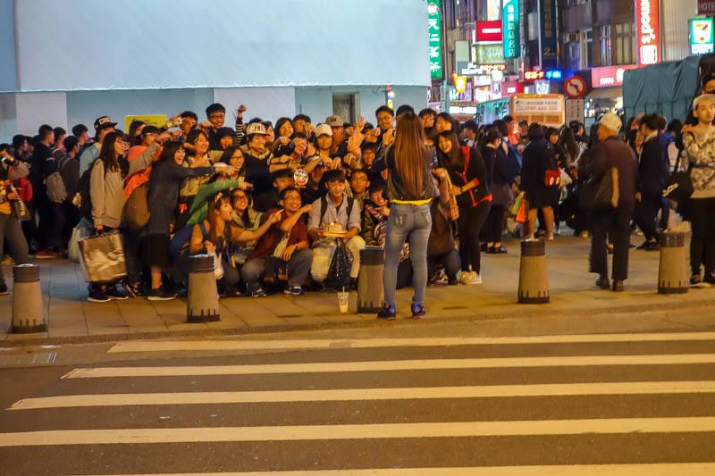 A full lap of Taiwan in March 2017 - A massive crowd has assembled on this corner, and many of them are holding cakes. The group at the front are posing for a photo showing off their cake